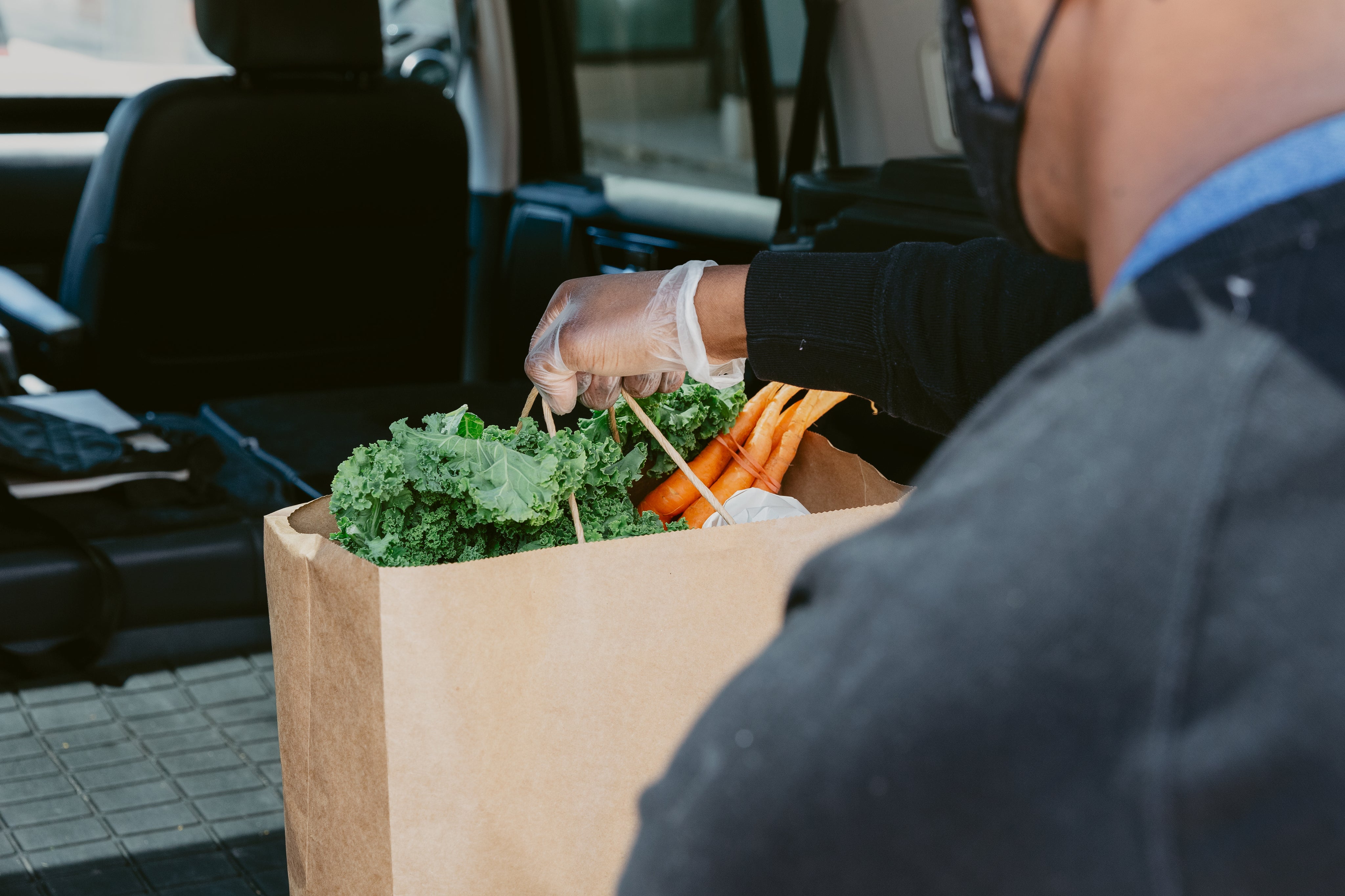 close-up-of-man-placing-groceries-in-back-of-car.jpg